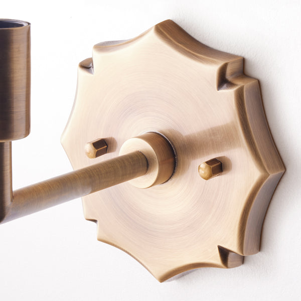 single insignia wall fixture in antiqued brass