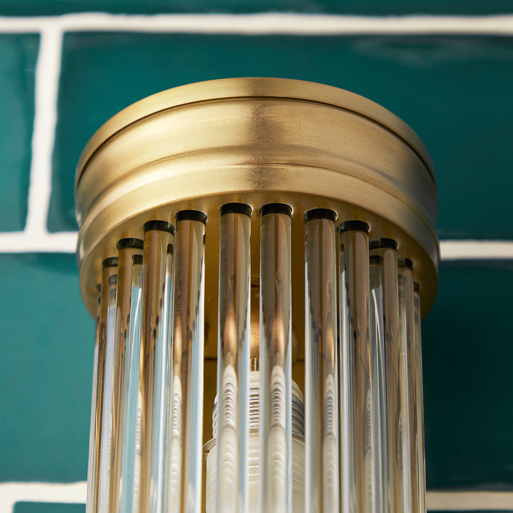 Long Roddy wall sconce in antiqued brass with glass rods