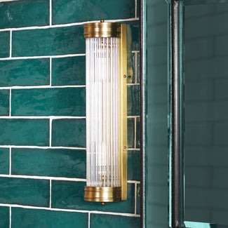 Long Roddy wall sconce in antiqued brass with glass rods